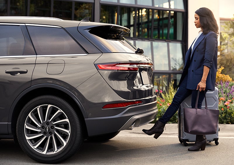 A woman with her hands full uses her foot to activate the available hands-free liftgate. | Irwin Lincoln in Freehold NJ