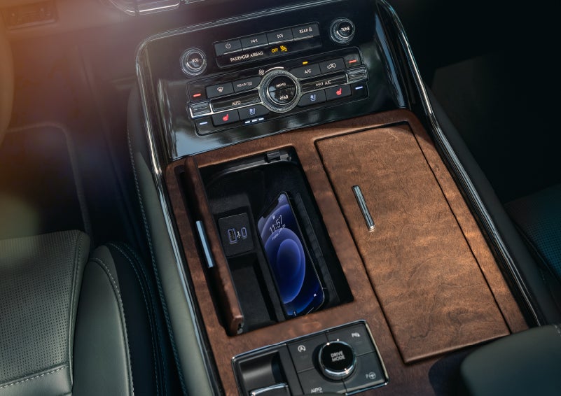 A smartphone is charging on the wireless charging pad in the front center console cubby | Irwin Lincoln in Freehold NJ