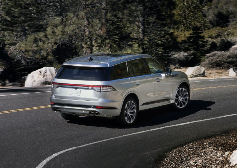 A 2023 Lincoln Aviator® Grand Touring model is shown being driven on a tight turn of a mountain road | Irwin Lincoln in Freehold NJ