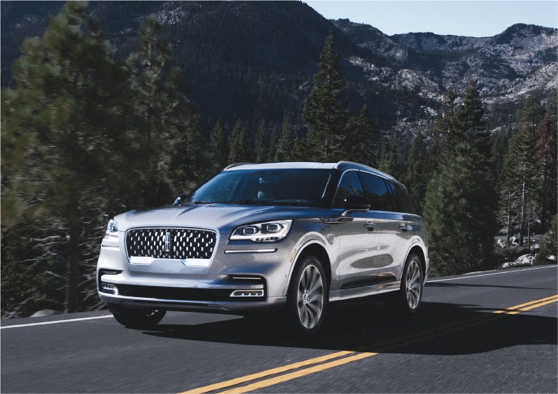 A 2023 Lincoln Aviator® Grand Touring SUV being driven on a winding road to demonstrate the capabilities of all-wheel drive | Irwin Lincoln in Freehold NJ