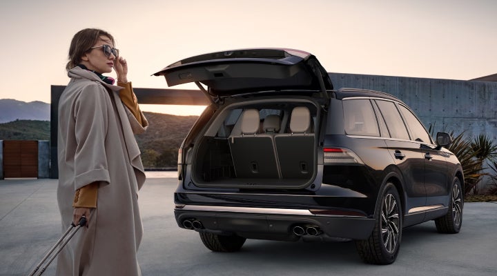 A woman approaches a 2026 Lincoln Aviator® SUV with its rear liftgate open. | Irwin Lincoln in Freehold NJ