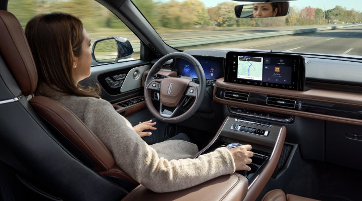 A 2026 Lincoln Aviator® SUV is being driven hands-free on a highway near a forest | Irwin Lincoln in Freehold NJ