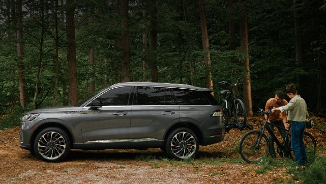 A father and son load e-bikes on a bike rack attached to a 2027 Lincoln Aviator® SUV. | Irwin Lincoln in Freehold NJ