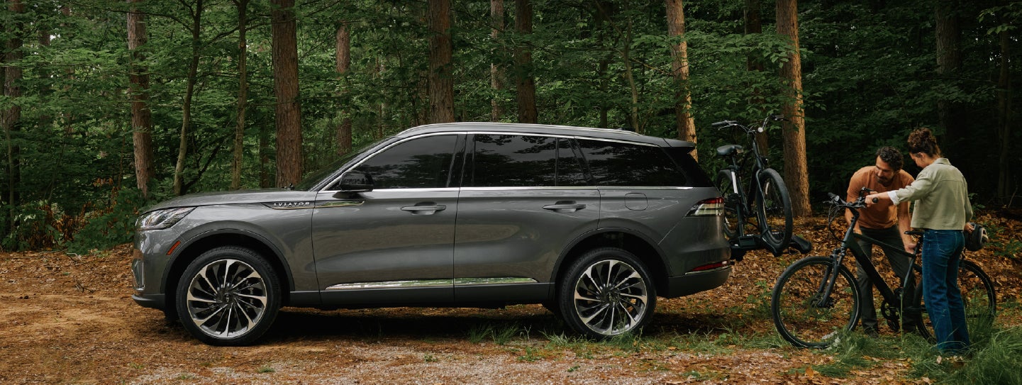 A father and son load e-bikes on a bike rack attached to a 2027 Lincoln Aviator® SUV. | Irwin Lincoln in Freehold NJ